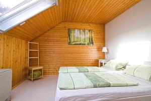 a bedroom with two beds and a wooden wall at Kempfenhof in Seelbach
