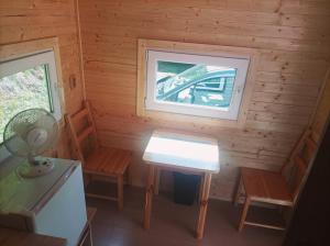 a small room with a table and chairs in a log cabin at Chata na kolech 4L v areálu Koupaliště Bystré v Orlických horách in Bystré