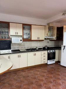 a kitchen with white cabinets and a white refrigerator at La Mary duplex in Federación