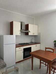 a kitchen with white cabinets and a wooden table at Laguna Blu Case Vacanza in Carbonia +48 photos