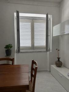 a dining room with a table and a window at Laguna Blu Case Vacanza in Carbonia