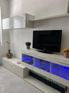 a living room with a television on a white entertainment center at Laguna Blu Case Vacanza in Carbonia