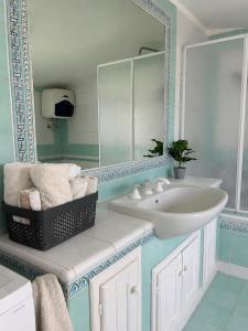 a bathroom with a sink and a mirror at Laguna Blu Case Vacanza in Carbonia