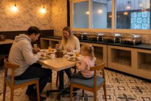 a family eating at a table in a restaurant at High Five Hotels Phase 2 in Assagao