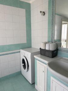 a bathroom with a washing machine and a sink at Laguna Blu Case Vacanza in Carbonia