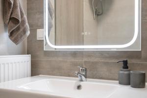 a bathroom with a sink and a mirror at Boheme Apartment in Leptokarya +16 photos