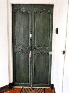 a pair of green doors in a room at Beautifully Bright Apartment in Old Town Saint-Tropez in Saint-Tropez