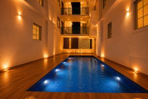 an indoor pool with lights in a building at High Five Hotels Phase 2 in Assagao