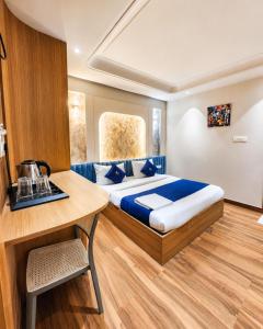 a bedroom with a bed and a wooden table at THE MASARA MANAR Hotel in Gwalior