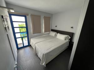 a bedroom with a white bed and a window at Playmar6970 in Maspalomas +15 photos