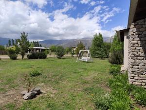a yard with a swing set in the grass at Tafi del Valle Casa Kabure in Tafí del Valle