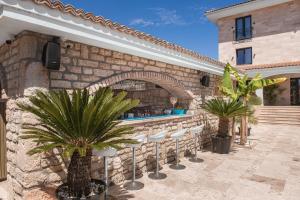 a patio with palm trees and a bar at Escape Vama Veche in Vama Veche