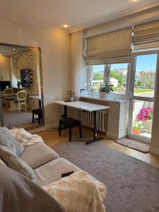 a living room with a couch and a table at Sunny Central Apartment on Central Square in Daugavpils
