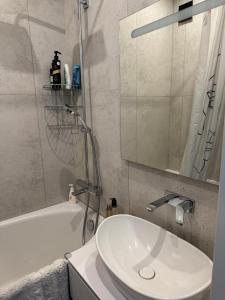 a bathroom with a sink and a mirror and a tub at Sunny Central Apartment on Central Square in Daugavpils