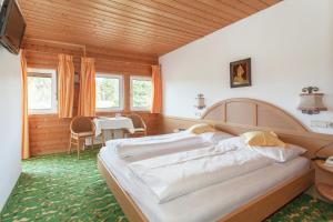 una camera da letto con un grande letto e un tavolo di Hotel Lichtenstern a Soprabolzano