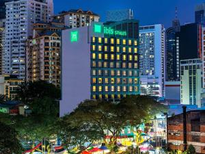 a tall building with a sign on it in a city at ibis Styles Kuala Lumpur Bukit Bintang in Kuala Lumpur
