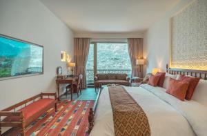 a hotel room with a large bed and a living room at Hunza Serena Hotel in Hunza Valley