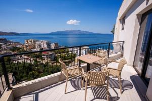 a balcony with a table and chairs and the ocean at Blissful Apartments in Sarandë