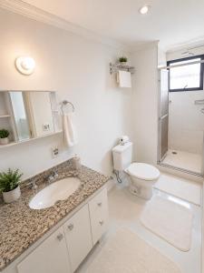 a white bathroom with a sink and a toilet at LEON MARIA HOSPEDAGENS - Smart Flat Hotel e Residence in Mogi das Cruzes