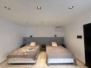 two beds in a room with white walls at Botanic Apart in Villa María