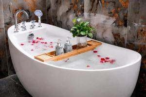 a white bath tub with red flowers on the floor at Tam Coc Center Friendly Hotel in Ninh Binh