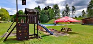 a playground with a slide and a picnic table at Chatka Agawa v areálu Koupaliště Bystré v Orlických horách in Bystré