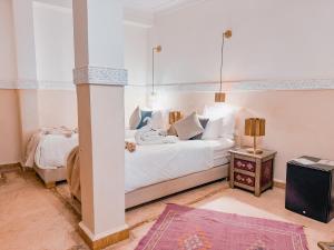 a bedroom with a large white bed and a table at Riad N'S & Spa in Marrakesh +86 photos