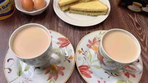 two cups of coffee sitting on plates on a table at Esther properties in Entebbe