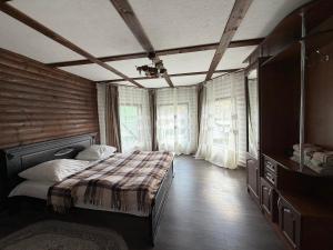 a bedroom with a bed in a room with windows at Sadyba u Anastasijky in Synevyr +67 photos