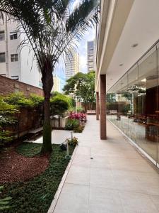 a courtyard with a palm tree and a building at Apto em Santos - UNIQUE Residence in Santos