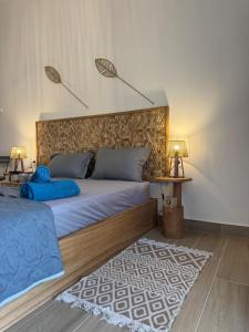 a bedroom with a large bed with a headboard and a rug at Seaview Apartments in Anavyssos +8 photos