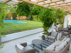 a patio with a table and chairs and a pool at Spacious House with Cottage&Pool in Nafplio