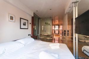 a bedroom with two beds and a flat screen tv at Youhosty - Duomo Studio Apartment in Milan