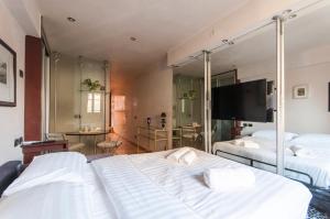 a bedroom with two beds and a large mirror at Youhosty - Duomo Studio Apartment in Milan
