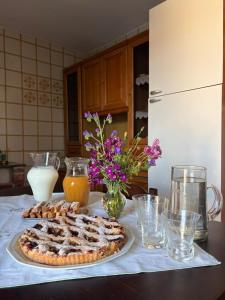 ein Tisch mit einem Kuchen, Getränken und Blumen in der Unterkunft U' Cerrito in Orria