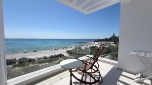 a balcony with a chair and a view of the beach at Le paradis 210 in Kelibia