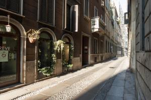 an empty street in an alley with buildings at Youhosty - Duomo Studio Apartment in Milan