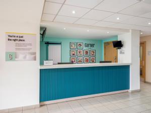 a waiting area in a hospital with a blue wall at Garner Hotel Wolverhampton by IHG in Wolverhampton