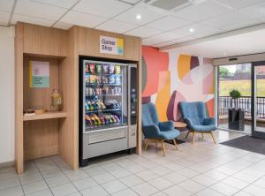 a store with two blue chairs and a refrigerator at Garner Hotel Wolverhampton by IHG in Wolverhampton