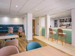 a restaurant with tables and chairs and a bar at Garner Hotel Wolverhampton by IHG in Wolverhampton
