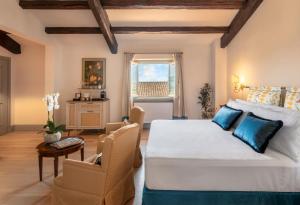 a bedroom with a large bed and a table and chairs at Borgo Tre Vaselle in Torgiano
