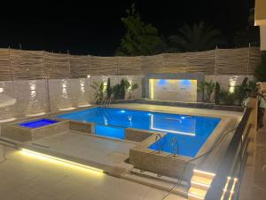 a swimming pool in a backyard at night at Krir city villa in Alexandria