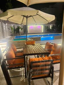 a table and chairs with an umbrella next to a pool at Krir city villa in Alexandria