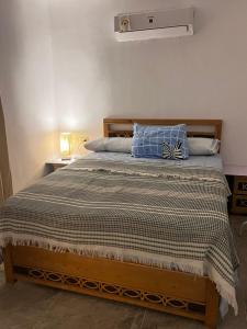 a bed with a blue pillow on top of it at Krir city villa in Alexandria