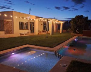 a backyard with a swimming pool and a house with lights at Luz de Alba in Argamasilla de Alba