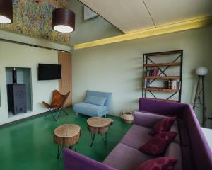 a living room with a purple couch and two tables at Luz de Alba in Argamasilla de Alba