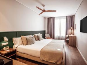 a hotel room with a large bed and a television at Hotel Well and Come Málaga in Málaga