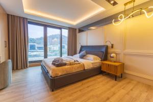 a bedroom with a bed and a large window at Leaf Villa Terra in Antalya