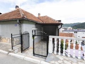 a white house with a gate and a balcony at Apartman Mila Raška in Raška