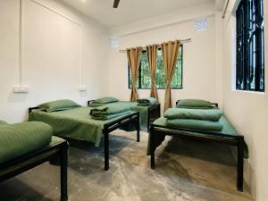 a room with two beds and a window at Goshen dormitory in Siliguri